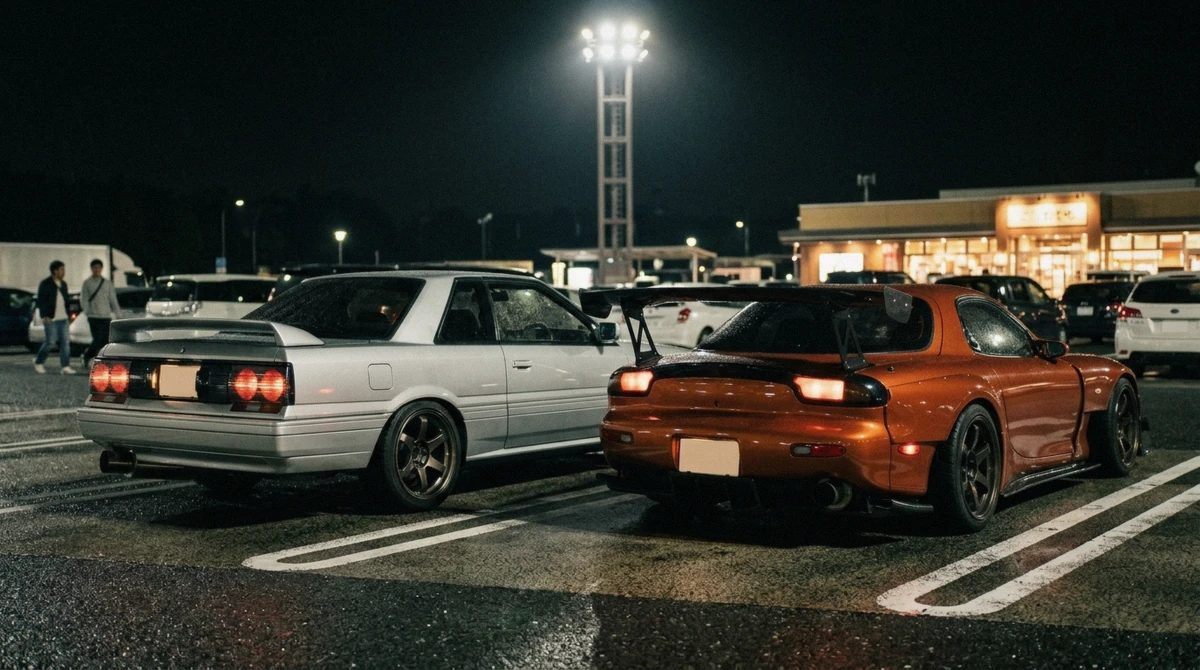 A modified Nissan GT-R and RX-7 parked side by side at the floodlit meet on a daikoku pa tour near Tokyo